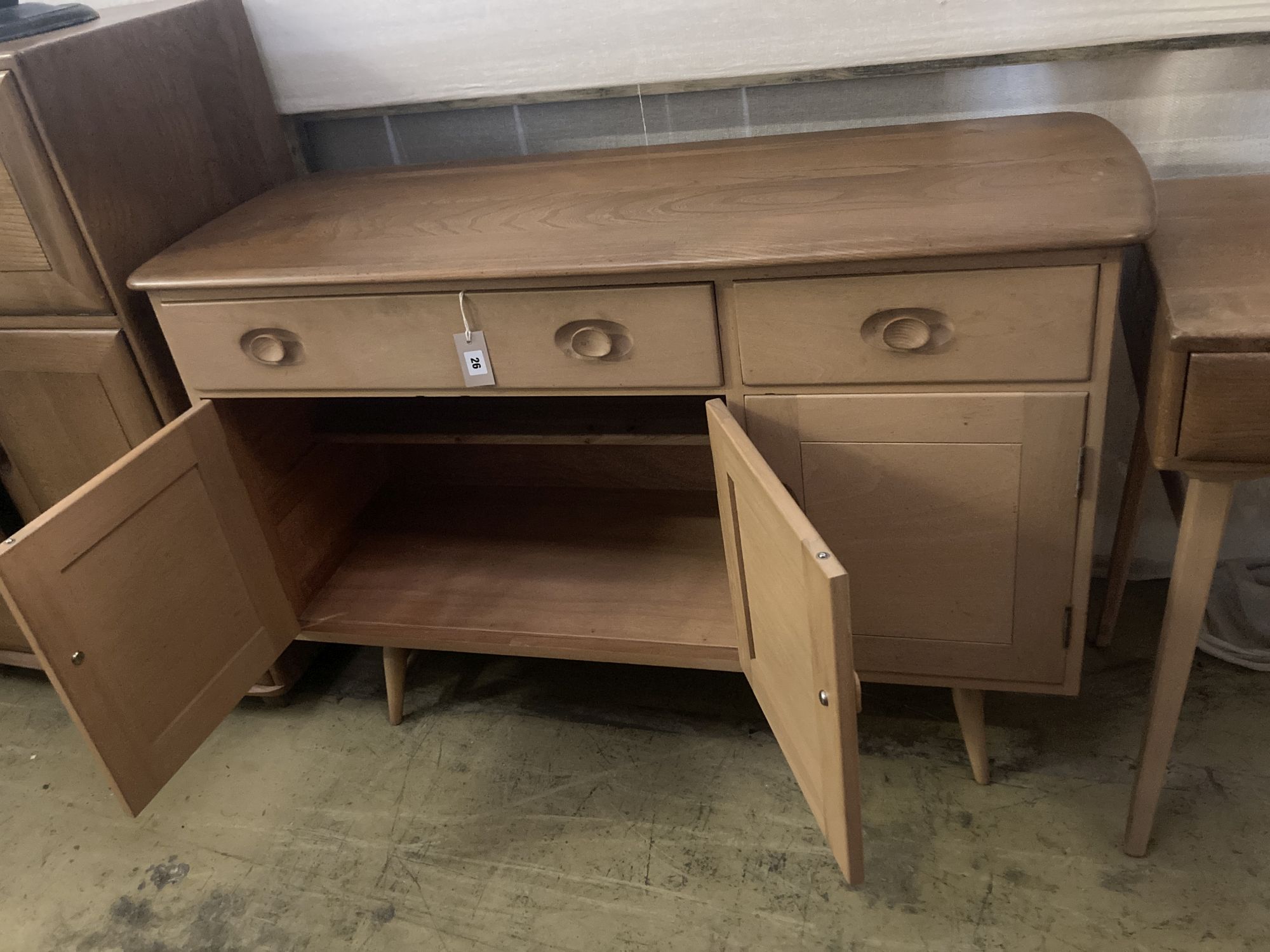 An Ercol elm sideboard (model no. 351), fitted one long drawer and one short drawer over three panelled doors, width 120cm depth 46cm h